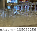 Glasses in a bar with reflections create a pattern against blurred colorful background 135022256