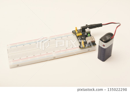 A solderless board for electronics with a battery. A breadboard for experiments in electronics. 135022298