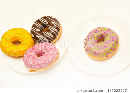 Sweet donuts on a plate. A delicious sweet snack. An American doughnut. Sweet donuts on a plate. A delicious sweet snack. An American doughnut. 135022327