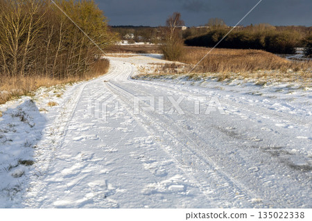 Frozen rural road in winter daylight landscape Frozen rural road in winter daylight landscape 135022338