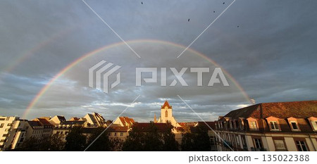 Double rainbow over Strasbourg rooftops with birds flying, mobile photo. Concept of weather, cityscape, nature, authenticity. Double rainbow over Strasbourg rooftops with birds flying, mobile photo. Concept of weather, cityscape, nature, authenticity. 135022388