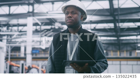 Technical Supervisor in Protective Hard Hat Audits System Performance With Tablet Technical Supervisor in Protective Hard Hat Audits System Performance With Tablet 135022435