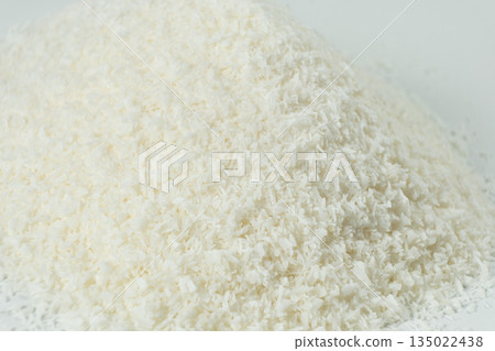 Pile of coconut flakes on white background macro Pile of coconut flakes on white background macro 135022438