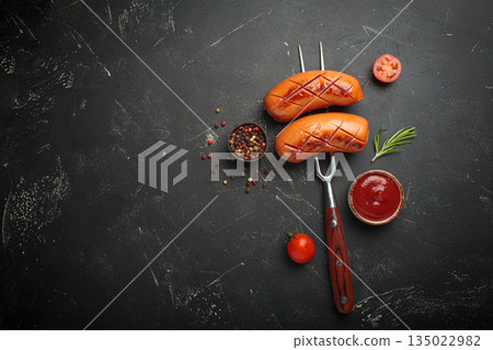 Grilled sausages fork ketchup spices bbq barbecue tomato black background copy space Grilled sausages fork ketchup spices bbq barbecue tomato black background copy space 135022982