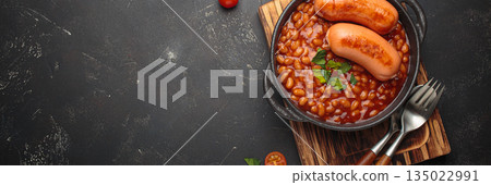 Baked beans tomato sauce grilled sausages cast iron pan English breakfast copy space 135022991