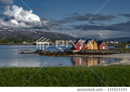 Coastal Landscape With Calm Fjord, Snowy Mountains With Wind Turbines And Cottages On Sommaroy Island  In Norway 135023334