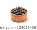 A bowl of black peppercorns on a white background 135023436