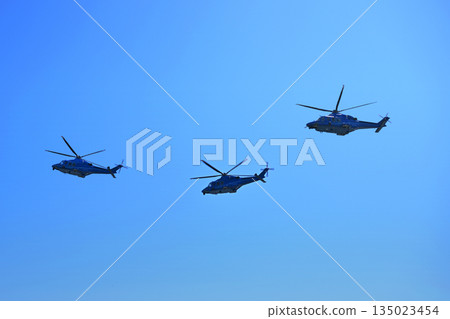 Helicopters fly under a blue sky. Tourist helicopter flights. Cargo delivery by air 135023454