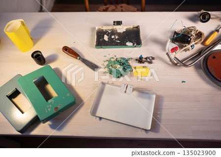 Worktable with tools and instruments at workshop, disassembling and restoring process of old lamp. 135023900
