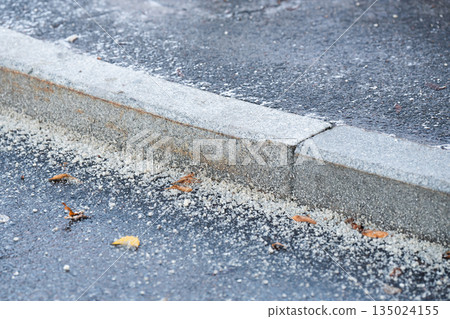 Frozen road sprinkled with chemicals and technical salt against ice formation in cold winter season. Frozen road sprinkled with chemicals and technical salt against ice formation in cold winter season. 135024155