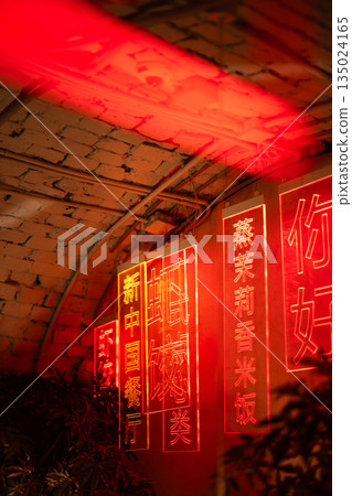 Interior and details of atmospheric chinese restaurant with colorful neon signs hanging on wall. 135024165