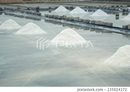 Farm in Vietnam with sea salt piles pyramids lying on ground ready for harvesting and collecting. Farm in Vietnam with sea salt piles pyramids lying on ground ready for harvesting and collecting. 135024172