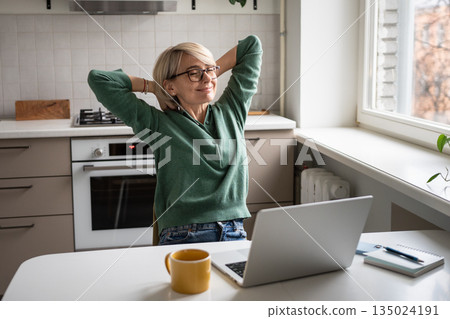 Happy businesswoman resting in chair stretching arms and smiling, satisfied after finishing tasks. 135024191