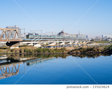 [Tokaido Main Line] A local train crossing the Tama River in the morning 135024624