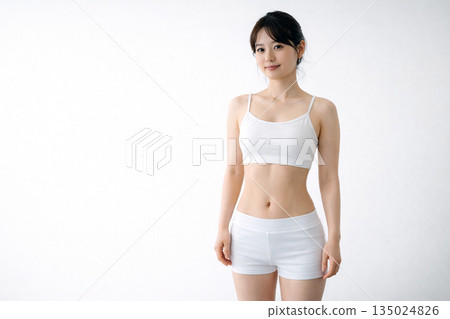 一個安靜的時刻，一位日本女性正在紮頭髮，她的腰線若隱若現。 135024826