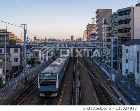 [Keihin-Tohoku Line] A local train passing through the streets of Kamata in the early morning 135024938