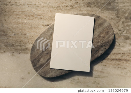 Blank paper sheet mockup, greeting card on marble stand, tray. Stone background in sunlight. Elegant stationery lat lay, top view. Minimal aesthetic, copy space for invitation, branding, logo Blank paper sheet mockup, greeting card on marble stand, tray. Stone background in sunlight. Elegant stationery lat lay, top view. Minimal aesthetic, copy space for invitation, branding, logo 135024979