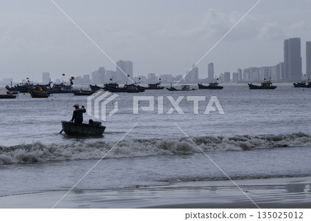 Vietnamese Fishing Boats Near Coastal City Skyline Vietnamese Fishing Boats Near Coastal City Skyline 135025012