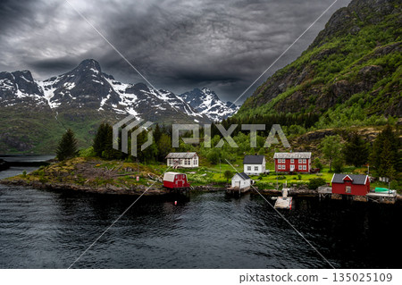 Coastal Landscape With Small Village And Snowy Mountains Near Trollfjord At The Lofoten In Norway Coastal Landscape With Small Village And Snowy Mountains Near Trollfjord At The Lofoten In Norway 135025109