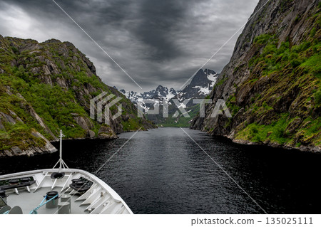 Cruise Ship Approaches High Bridge Over Calm Fjord Near Stokmarknes At The Lofoten In Norway Cruise Ship Approaches High Bridge Over Calm Fjord Near Stokmarknes At The Lofoten In Norway 135025111