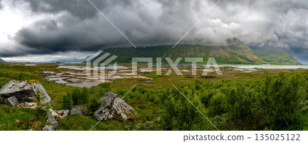 Cloudy Mountains And Calm Fjord With Bridge On Lofoten Islands In Norway Cloudy Mountains And Calm Fjord With Bridge On Lofoten Islands In Norway 135025122