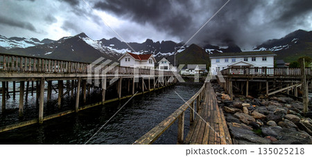 Cottages, Wooden Pier And Snowy Mountains In Mefjordvaer On Senja Island In Norway Cottages, Wooden Pier And Snowy Mountains In Mefjordvaer On Senja Island In Norway 135025218