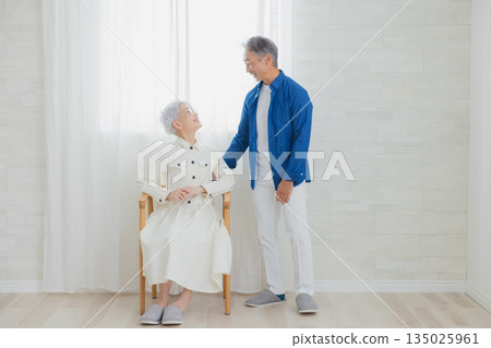 客廳裡一對面帶著微笑的老年夫婦 客廳裡一對面帶著微笑的老年夫婦 135025961