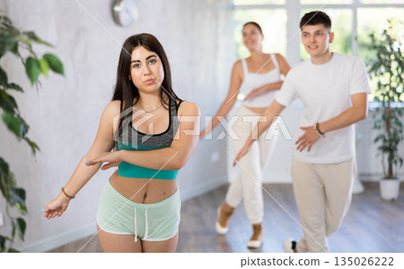Girl teen perform choreographic exercise and teach energetic house dance with friends 135026222