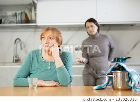 Frustrated mature woman after a conflict with her daughter Frustrated mature woman after a conflict with her daughter 135026316