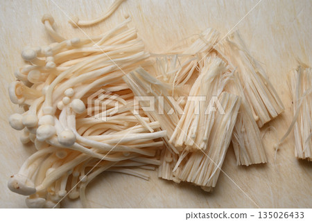 Enoki mushrooms cut on a cutting board 135026433