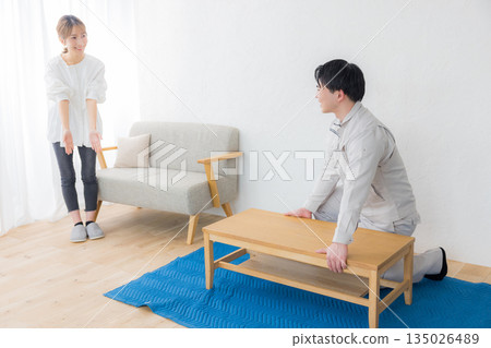 A man wearing work clothes and a woman requesting delivery 135026489