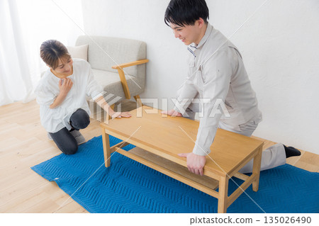 A man wearing work clothes and a woman requesting delivery 135026490