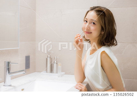 Young woman looking at a mirror 135026502