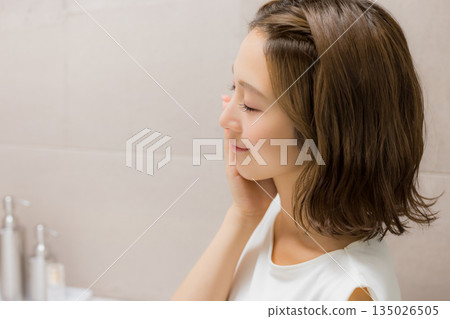 Young woman looking at a mirror 135026505