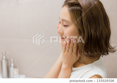 Young woman looking at a mirror Young woman looking at a mirror 135026506