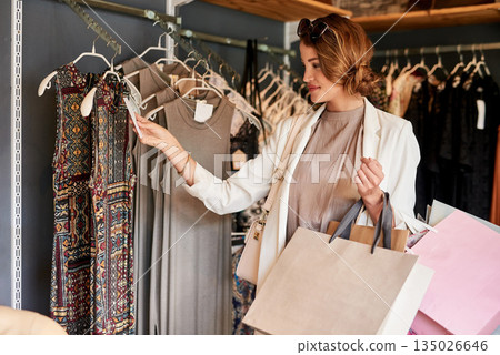 Shopping, fashion and woman with luxury, boutique and client with wealth, style and clothes selection. Female person, customer or shopper in a store, outfit choice and buying with discount and retail Shopping, fashion and woman with luxury, boutique and client with wealth, style and clothes selection. Female person, customer or shopper in a store, outfit choice and buying with discount and retail 135026646
