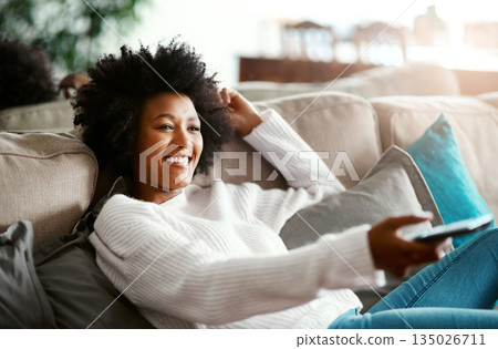 Black woman, watching tv and relax on sofa with remote, smile and happiness for film, comedy or show. African girl, television and happy for movie, video and browsing on lounge couch in apartment Black woman, watching tv and relax on sofa with remote, smile and happiness for film, comedy or show. African girl, television and happy for movie, video and browsing on lounge couch in apartment 135026711