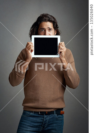 Tablet screen, mockup and portrait of man peeking in studio isolated on a gray background. Touchscreen, scared and male person with space for marketing, advertising and technology for promotion. Tablet screen, mockup and portrait of man peeking in studio isolated on a gray background. Touchscreen, scared and male person with space for marketing, advertising and technology for promotion. 135026840