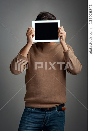 Tablet screen, space and man covering face in studio isolated on a gray background. Touchscreen, hiding and male person with mockup for marketing, advertising and technology for commercial promotion. Tablet screen, space and man covering face in studio isolated on a gray background. Touchscreen, hiding and male person with mockup for marketing, advertising and technology for commercial promotion. 135026841