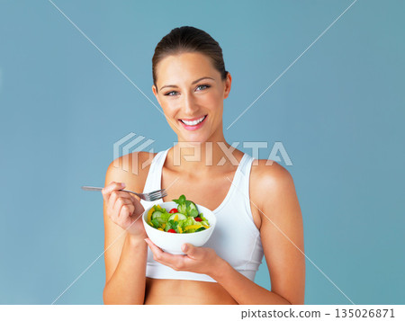 Woman in portrait, smile and eating salad, diet and healthy food with weight loss isolated on blue background. Health, wellness and nutrition with vegetables, female model in studio and mockup space Woman in portrait, smile and eating salad, diet and healthy food with weight loss isolated on blue background. Health, wellness and nutrition with vegetables, female model in studio and mockup space 135026871