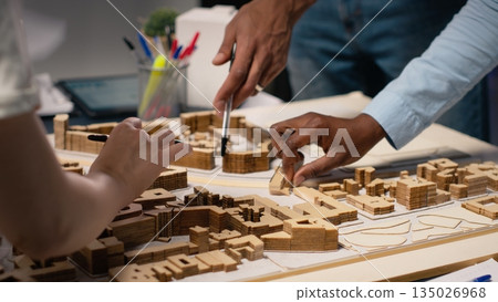 Close up of engineers team creating the property layout for site preparation, using 3D models for urban development and construction project. Infrastructure growth and city planning. 135026968