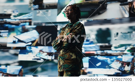 Air defense commander using radar systems digital interface to detect incoming ballistic missiles. Portrait of army soldier with arms crossed in base of operations scanning enemy rockets, camera B 135027000