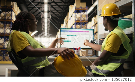 African american warehouse clerks monitors parcel status on package tracking software, managing e-commerce logistics and shipment route to update clients in real time. Order fulfillment. Camera A. African american warehouse clerks monitors parcel status on package tracking software, managing e-commerce logistics and shipment route to update clients in real time. Order fulfillment. Camera A. 135027012