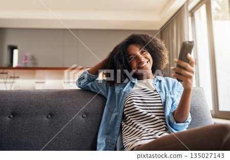 Relax, black woman with remote and watching tv on sofa in living room of her home. Entertainment or comfort, streaming movie or a series and happy African female person watch television on a couch Relax, black woman with remote and watching tv on sofa in living room of her home. Entertainment or comfort, streaming movie or a series and happy African female person watch television on a couch 135027143