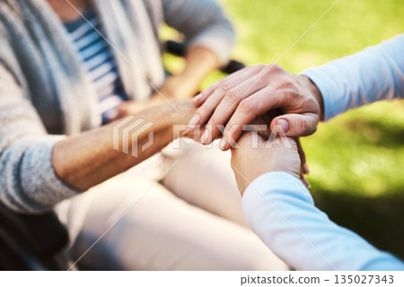 Senior woman, caregiver and holding hands in support care or love for healthcare or life insurance in nature. Hand of nurse helping or nursing mature patient in wheelchair or person with a disability Senior woman, caregiver and holding hands in support care or love for healthcare or life insurance in nature. Hand of nurse helping or nursing mature patient in wheelchair or person with a disability 135027343