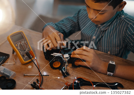 Education, car robot and top view of child with homework, homeschool and science, learning and tech project. Robotics, building and boy kid with electrical knowledge, engineering or studying in house Education, car robot and top view of child with homework, homeschool and science, learning and tech project. Robotics, building and boy kid with electrical knowledge, engineering or studying in house 135027382