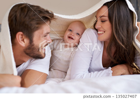 Happy mother, father and baby with blanket on bed for love, care and quality time together. Parents, family and playful newborn child relaxing in bedroom with bedding fort, smile and bonding at home Happy mother, father and baby with blanket on bed for love, care and quality time together. Parents, family and playful newborn child relaxing in bedroom with bedding fort, smile and bonding at home 135027407