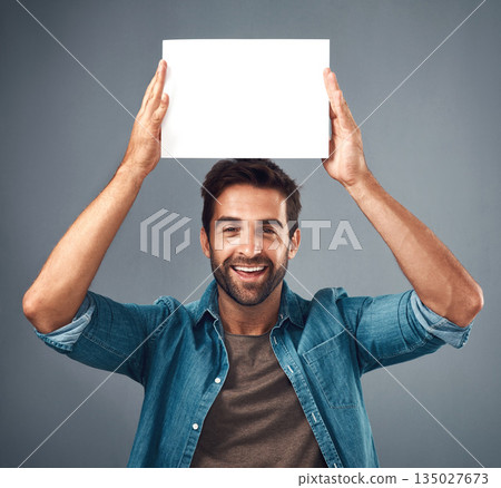 Happy man, portrait and poster on mockup for advertising, marketing or branding against a grey studio background. Male person holding rectangle billboard or placard for sign, message or advertisement 135027673