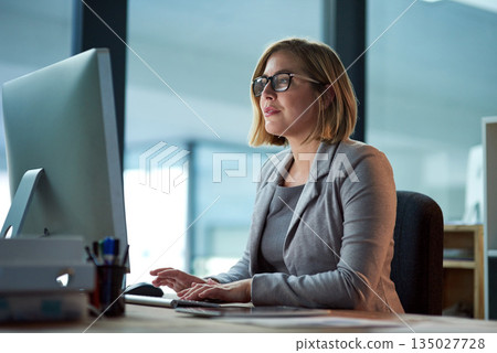 Computer, typing and business woman in office working late on project at night alone. Desktop, professional and female person writing email, report or planning, reading and overtime for deadline. Computer, typing and business woman in office working late on project at night alone. Desktop, professional and female person writing email, report or planning, reading and overtime for deadline. 135027728