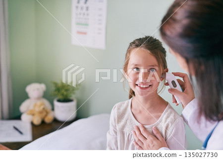 Healthcare, kids and a girl at the pediatrician for an ear exam, appointment or checkup in the hospital. Medical, happy and temperature with an adorable female child sitting on a bed in the clinic Healthcare, kids and a girl at the pediatrician for an ear exam, appointment or checkup in the hospital. Medical, happy and temperature with an adorable female child sitting on a bed in the clinic 135027730